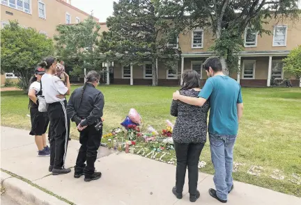  ?? ARI BURACK/THE NEW MEXICAN ?? People gather at a descanso for Ernestine Saucedo in front of the Jerry Apodaca Education Building on Friday.