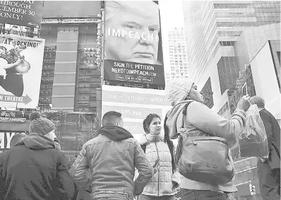  ??  ?? UN CARTEL en Times Square, NY, financiado por el filántropo Tom Steyer, pide el juicio político al presidente Donald Trump