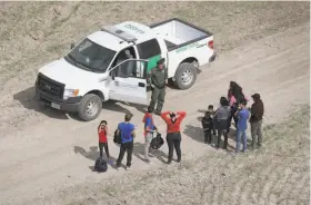  ?? John Moore / Getty Images ?? Asylum seekers turn themselves in to a U.S. Border Patrol agent after crossing from Mexico into the United States in Mission, Texas, last week.