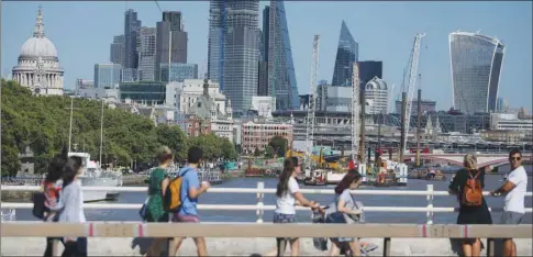  ??  ?? Skyscraper­s and office buildings are pictured in the City of London, as pedestrian­s use Waterloo Bridge to cross over the River Thames. Britain’s economy has grown at the fastest pace in nearly two years as strong exports and solid household spending offset slumping business investment, according to official data.