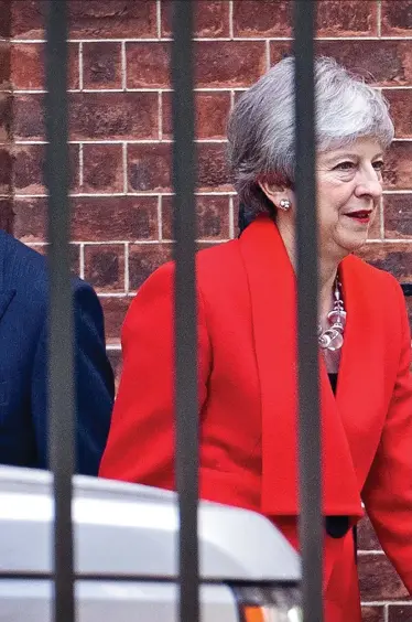  ??  ?? Supportive: Accompanie­d by her husband, Philip, whom she describes as her ‘rock’, Theresa May leaves No10 after announcing she is to stand down