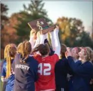  ?? AIMEE BIELOZER — THE MORNING JOURNAL ?? The Bay Rockets hoist the Division II, Region 6 trophy after defeating Wapakoneta on Nov. 3.