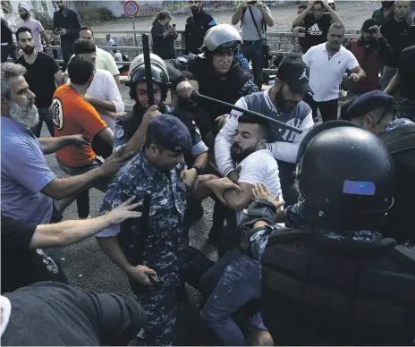  ?? AP ?? Above, Hezbollah supporters and Lebanese riot police clash in Beirut yesterday; left, Prime Minister Saad Hariri hands his resignatio­n to President Michel Aoun