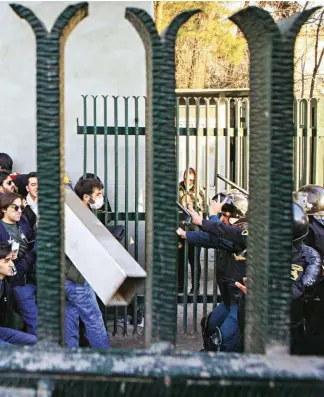  ??  ?? Studenti iraniani durante uno scontro con la polizia antisommos­sa attorno alla università di Teheran il 30 dicembre scorso.