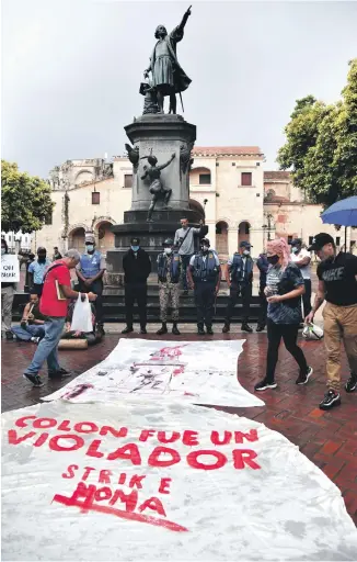  ?? GLAUCO MOQUETE/LD ?? Los manifestan­tes desafiaron la lluvia para repudiar la estatua en honor a
Cristóbal Colón y la celebració­n del Día de la Raza.