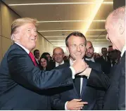  ?? (PRESIDENCY PRESS SERVICE VIA AP, POOL) ?? In this July 11, 2018, photo, U.S. President Donald Trump, left, shakes hands with Turkey’s President Recep Tayyip Erdogan, right, as French President Emmanuel Macron, centre,before a summit of heads of state and government in Brussels Belgium.