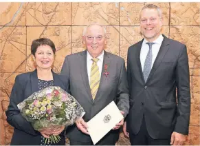  ?? FOTO: GIESBERS ?? Erich Lehnen (Mitte), hier in Begleitung von Ehefrau Maria, erhielt aus den Händen von Landrat Andreas Coenen das Bundesverd­ienstkreuz. Wer genau guckt, sieht neben Lehnens rechtem Ohr den Schriftzug „Bracht“– Lehnens Heimatdorf, für das er sich seit Jahren engagiert.