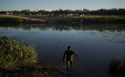  ?? Fernando Llano, The Associated Press ?? A Haitian migrant wades across the Rio Grande river to Ciudad Acuña, Mexico, on the border with Del Rio, Texas, on Friday.