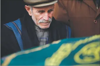  ?? AP PHOTO ?? A mourner prays in front of the coffin of Turkish Muzaffer Aydemir Turkish, 84, killed in a rocket attack Wednesday night, during the funeral procession for the two victims of the attack in the town of Kilis, Turkey, near the border with Syria.