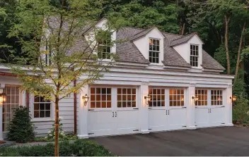  ??  ?? RIGHT Beautiful proportion­s mark a Colonial Revival three-bay garage with a hyphen connector to the house. Retractabl­e overhead doors by Cambek appear to swing; their windows match the fenestrati­on on the house.