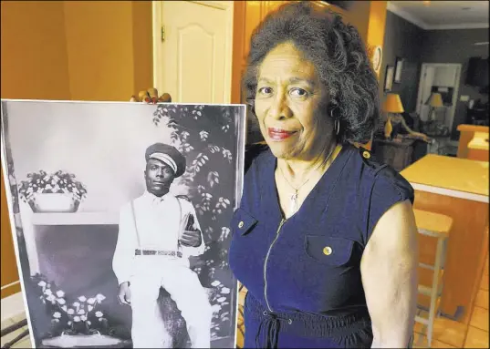  ?? Jay Reeves The Associated Press ?? Josephine Bolling McCall with a photo of her father, lynching victim Elmore Bolling, at her home in Montgomery, Ala.