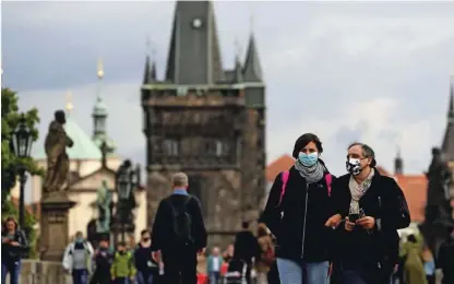  ?? Foto David W Cerny/Reuters ?? Po Karlovem mostu v Pragi se lahko ljudje sprehajajo le z zaščitno masko.