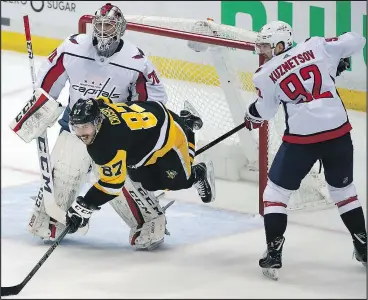  ?? THE ASSOCIATED PRESS ?? Penguins captain Sidney Crosby is upended in front of the Capitals’ net by Evgeny Kuznetsov last night during their second-round playoff series in Pittsburgh.