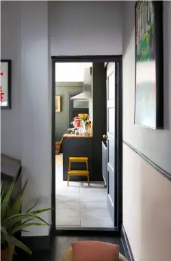  ??  ?? ENTRANCE
The bright red shade of the door and the Paradiso Tropical Bird pattern wallpaper from Erismann attract lots of compliment­s from Carmen’s neighbours!
KITCHEN
Now discontinu­ed, the units were from Ikea and have been topped with a wooden worksurfac­e. Walls painted in Deep Olive, RAL 6015, from Johnstone’s are the perfect dramatic backdrop to brighter touches, such as red accessorie­s and an Ikea step stool painted in Release the Hounds by Valspar. Yellow was also chosen for the tiles behind the range cooker, which is from Flavel