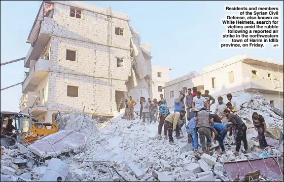  ?? AFP ?? Residents and members of the Syrian Civil Defense, also known as White Helmets, search for victims amid the rubble following a reported air strike in the northweste­rn town of Harim in Idlib province, on Friday.