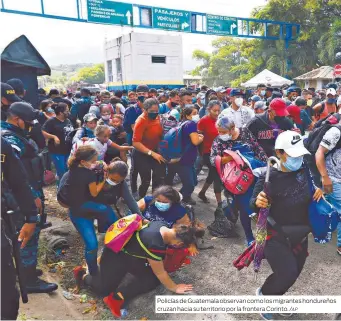  ?? /AP ?? Policías de Guatemala observan como los migrantes hondureños cruzan hacia su territorio por la frontera Corinto.