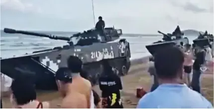  ?? ?? Show of strength: Footage on Chinese social media shows tanks rolling along a beach on the mainland