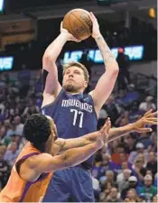  ?? TONY GUTIERREZ AP ?? Mavericks’ Luka Doncic, who had 26 points, shoots over Suns’ Cameron Payne in the second half.