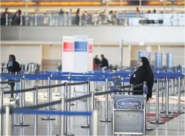  ?? REUTERS ?? An airline worker stands in the empty internatio­nal terminal at LAX Airport in Los Angeles on Wednesday.