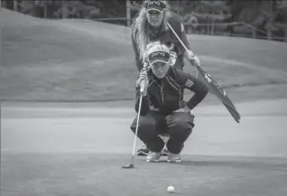  ?? JEFF MCINTOSH, THE CANADIAN PRESS ?? Brooke Henderson, with her caddie sister Brittany Henderson behind her, assess a putt during the LPGA Canadian Open in Priddis, Alta. Northern Ireland’s Stephanie Meadow leads after the first round.