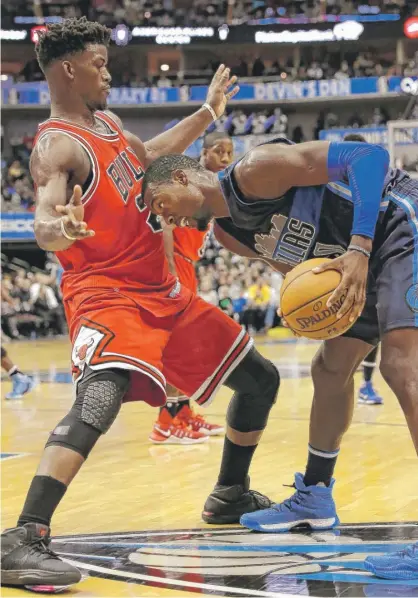  ?? | AP/ LM OTERO ?? Jimmy Butler guards Mavericks forward Harrison Barnes on Saturday in Dallas. Butler led the Bulls with 26 points.