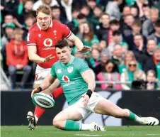  ?? — AFP photo ?? Wales’ fly-half Sam Costelow (left) vies with Ireland’s wing Calvin Nash during the Six Nations internatio­nal rugby union match between Ireland and Wales at the Aviva Stadium in Dublin.