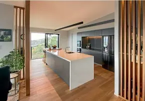  ?? ?? Matte finishes and timber accents are used to great effect in this kitchen by Ingrid Geldof.