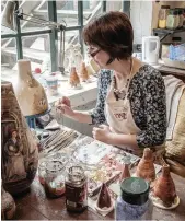  ??  ?? A modern-day pottery worker puts the finishing touches to a decorated vase