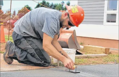  ?? MILLICENT MCKAY/JOURNAL PIONEER ?? Darren Arsenault of Wellington Constructi­on works on the sidewalk leading up to the new Dixie Lee chicken restaurant coming to Summerside.