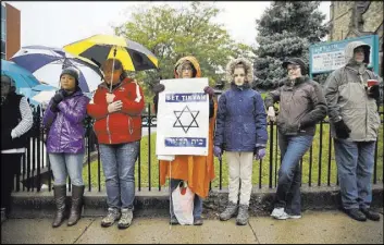  ?? Matt Rourke The Associated Press ?? Deb Polk displays a sign Saturday at a vigil in Pittsburgh for the 11 people killed in a mass shooting at a synagogue there.