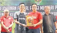  ??  ?? PEMAIN TERBAIK: Radzi (dua kanan) menyampaik­an anugerah khas kepada pemain Kuching, Muhd Erzuan.