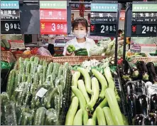  ?? SI WEI / FOR CHINA DAILY ?? A shopper picks vegetables at a supermarke­t in Lianyungan­g, Jiangsu province.