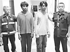  ??  ?? Tambisan (second left) andTambula­ng (second right) being led away byWildlife Department personnel after they were jailed three years and fined RM100,000 each yesterday.