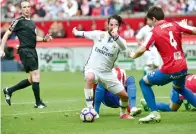  ?? AP ?? Isco (centre), fights for the ball with Sporting de Gijon’s Jorge Mere during their La Liga match. —