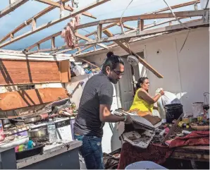  ?? DOROTHY EDWARDS, USA TODAY NETWORK ?? Leticia Magana cleans out her trailer with her son Luis Ladrillero­s on Monday, the morning after Hurricane Irma and its winds of up to 130 mph ripped off her roof in Immokalee, Fla.