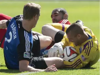  ?? CHRIS YOUNG/THE CANADIAN PRESS ?? Earthquake­s goalkeeper Jon Busch hangs on to the ball under pressure from Toronto FC forwards at BMO Field.