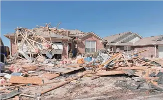  ?? Photos by Alonzo Adams/Associated Press ?? Debris covers homes along Frost Lane on Monday in Norman, Okla. The damage came after rare severe storms and tornadoes moved through Oklahoma overnight.