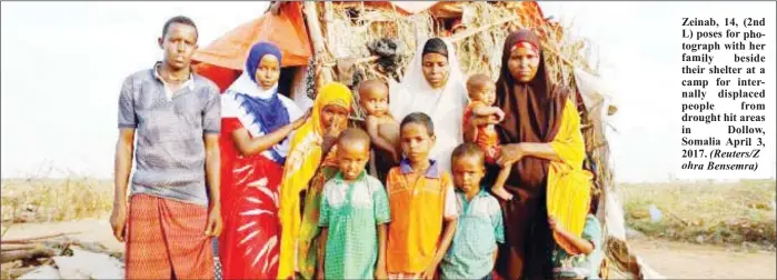  ??  ?? Zeinab, 14, (2nd L) poses for photograph with her family beside their shelter at a camp for internally displaced people from drought hit areas in Dollow, Somalia April 3, 2017.