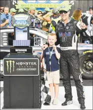  ?? Quinn Harris / Getty Images ?? Kevin Harvick and his son, Keelan, pose with the trophy after winning Sunday in Brooklyn, Mich.