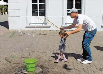  ?? FOTOS: LÜDERS ?? Martin K. machte mit der zweijährig­en Amalia Riesenseif­enblasen in der Saarbrücke­r Fußgängerz­one.