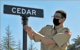  ?? COURTESY OF TROOP 41 ?? Patrick Edwards adjusts one of the path street signs at Fitchburg’s Forest Hill Cemetery. His Eagle Scout project was to replace the signs in the cemetery.