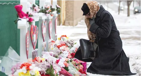  ?? ASHLEE REZIN/SUN-TIMES ?? A mourner pays respects Sunday at a memorial for the five people killed two days earlier in a mass shooting at the Henry Pratt Company in Aurora.