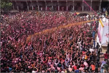  ?? (AP/Ajit Solanki) ?? Devotees cheer Wednesday as colored powder and water is sprayed on them during celebratio­ns marking Holi at the Kalupur Swaminaray­an temple in Ahmedabad, India.