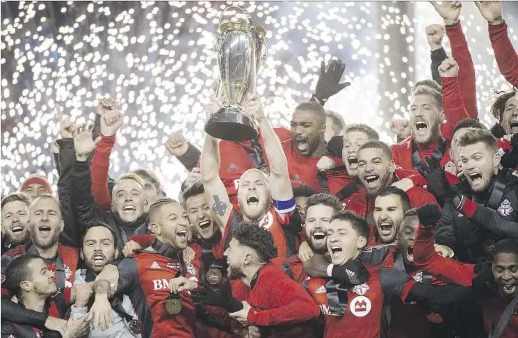  ?? NATHAN DENETTE/THE CANADIAN PRESS ?? Toronto FC midfielder Michael Bradley hoists the MLS Cup with his teammates after defeating the Seattle Sounders on Dec. 9.