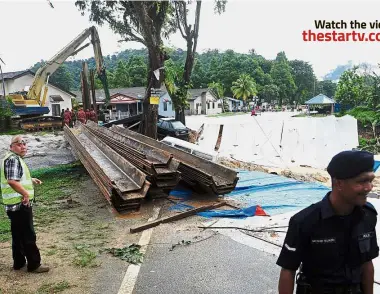  ??  ?? Work in progress: The Public Works Department is working round the clock to sheet pile the area to stop the soil from moving further. — Bernama