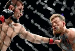  ?? AP ?? Khabib Nurmagomed­ov, left, lands a punch to Conor McGregor’s throat during their lightweigh­t title mixed martial arts bout in Las Vegas last Sunday.