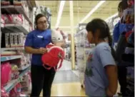  ?? THE ASSOCIATED PRESS ?? Mitzi Solorio, a former seasonal employee now working full time, helps out a customer at a Toys R Us store in San Jose, Calif., on Sept. 30.