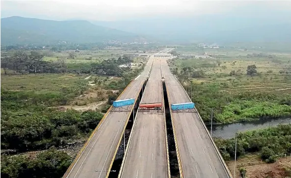  ?? AP ?? A fuel tanker, cargo trailers and makeshift fencing block the Tienditas Internatio­nal Bridge in an attempt to stop humanitari­an aid entering from Colombia, as seen from the outskirts of Cucuta, on Colombia’s border with Venezuela.