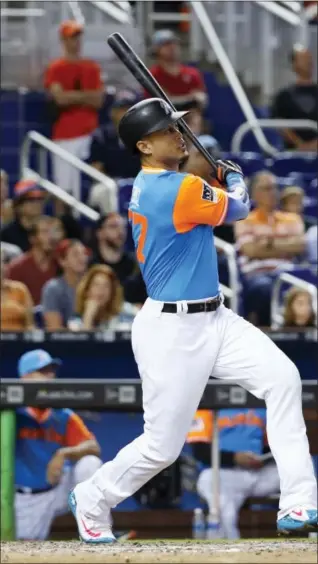  ?? WILFREDO LEE — THE ASSOCIATED PRESS ?? Miami Marlins’ Giancarlo Stanton watches the ball after he hit a home run during the eighth inning against the San Diego Padres Sunday. Stanton hit his 50th home run to break an eighth-inning tie, helping the Marlins sweep the Padres.