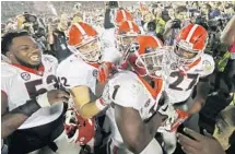  ?? DOUG BENC/AP ?? Georgia tailback Sony Michel (1) is mobbed by his teammates after scoring the game-winning touchdown in the second overtime period.